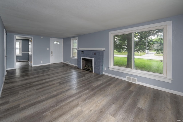 1201 Canal St, New Haven, IN 46774 - unfurnished living room featuring a tiled fireplace and dark wood-style flooring