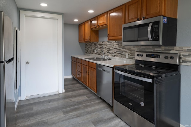 1201 Canal St, New Haven, IN 46774 - kitchen featuring appliances with stainless steel finishes, light countertops, light wood-style floors, backsplash, and recessed lighting