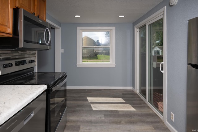 1201 Canal St, New Haven, IN 46774 - kitchen with appliances with stainless steel finishes, brown cabinets, a textured ceiling, dark wood-type flooring, and recessed lighting
