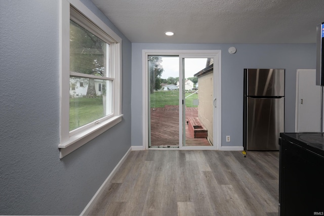 1201 Canal St, New Haven, IN 46774 - entryway featuring wood finished floors, plenty of natural light, and a textured ceiling