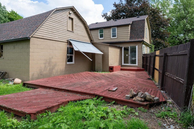 1201 Canal St, New Haven, IN 46774 - rear view of house with a gambrel roof, roof with shingles, a fenced backyard, and a deck