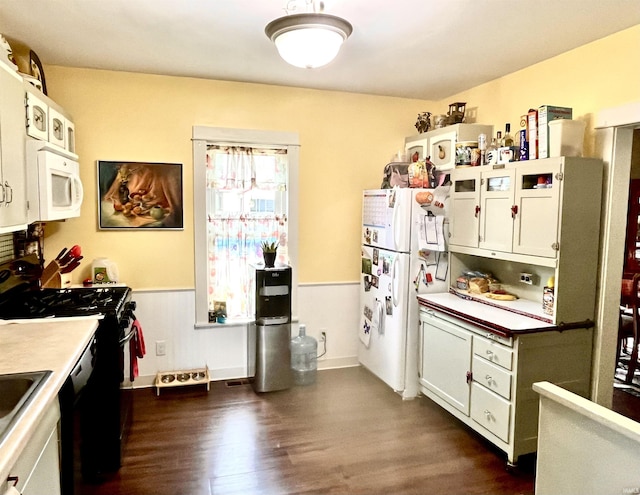 946 S 23rd St, South Bend, IN 46615 - kitchen featuring black appliances, dark wood finished floors, light countertops, and white cabinets