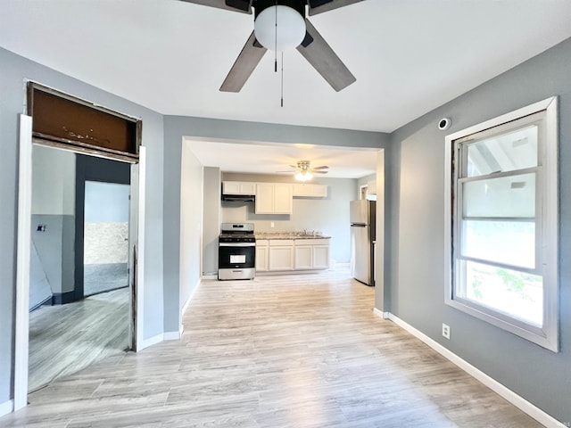 251 E 5th St, Peru, IN 46970 - kitchen with stainless steel appliances, a ceiling fan, light wood finished floors, light countertops, and white cabinets