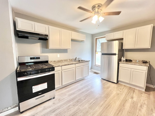 251 E 5th St, Peru, IN 46970 - kitchen with stainless steel appliances, under cabinet range hood, ceiling fan, and light wood-type flooring