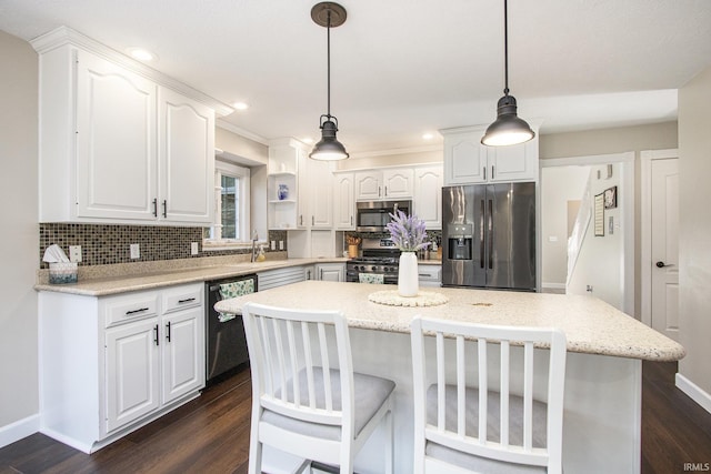 57329 Orchard Ridge Dr, Elkhart, IN 46516 - kitchen featuring appliances with stainless steel finishes, backsplash, white cabinetry, dark wood finished floors, and a kitchen island
