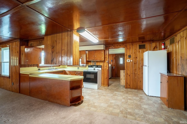 2200 S 460 E, Lagrange, IN 46761 - kitchen featuring white appliances, brown cabinets, wood walls, a peninsula, and washer / dryer