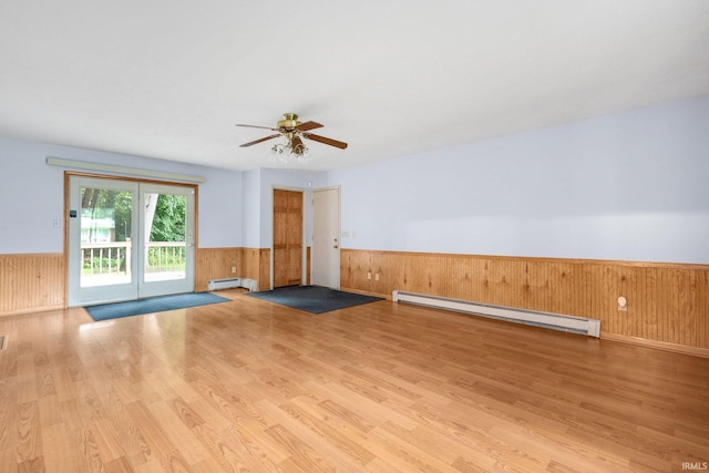 26247 Douglas Ave, Elkhart, IN 46514 - spare room with a baseboard heating unit, wainscoting, baseboard heating, wood finished floors, and a ceiling fan