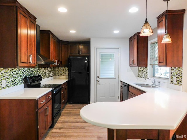 185 W Mercury St, Markle, IN 46770 - kitchen with black appliances, wall chimney range hood, a peninsula, light countertops, and decorative backsplash