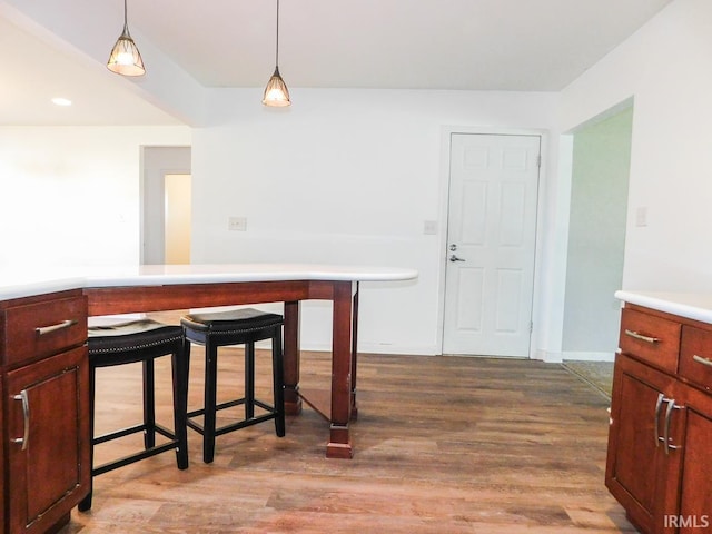 185 W Mercury St, Markle, IN 46770 - kitchen with wood finished floors, hanging light fixtures, light countertops, and a kitchen bar