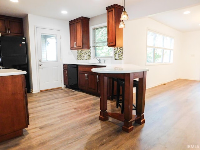 185 W Mercury St, Markle, IN 46770 - kitchen with black appliances, light wood-type flooring, a kitchen breakfast bar, recessed lighting, and decorative backsplash
