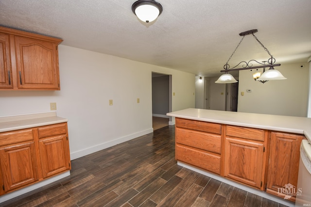 4044 S Younkin Dr, Redkey, IN 47373 - kitchen with dark wood-type flooring, light countertops, brown cabinetry, pendant lighting, and a textured ceiling