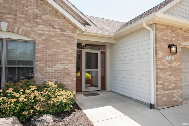 344 Rosebank Ln, West Lafayette, IN 47906 - entrance to property featuring a shingled roof, brick siding, and an attached garage