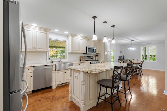 1704 S Sutton Circle Dr, Bluffton, IN 46714 - kitchen featuring appliances with stainless steel finishes, wood finished floors, a kitchen breakfast bar, a kitchen island, and recessed lighting