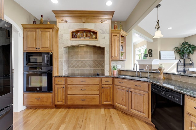 1669 E Brookside Trl, Columbia City, IN 46725 - kitchen with black appliances, light wood finished floors, backsplash, dark stone counters, and hanging light fixtures