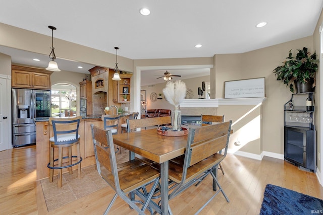 1669 E Brookside Trl, Columbia City, IN 46725 - dining space featuring a ceiling fan, light wood-type flooring, recessed lighting, a glass covered fireplace, and arched walkways