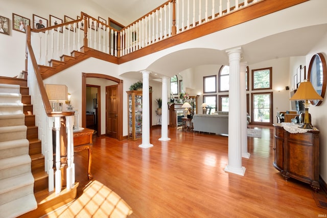 1726 Tall Oaks Dr, Kokomo, IN 46901 - entrance foyer featuring decorative columns, arched walkways, wood finished floors, a towering ceiling, and stairway