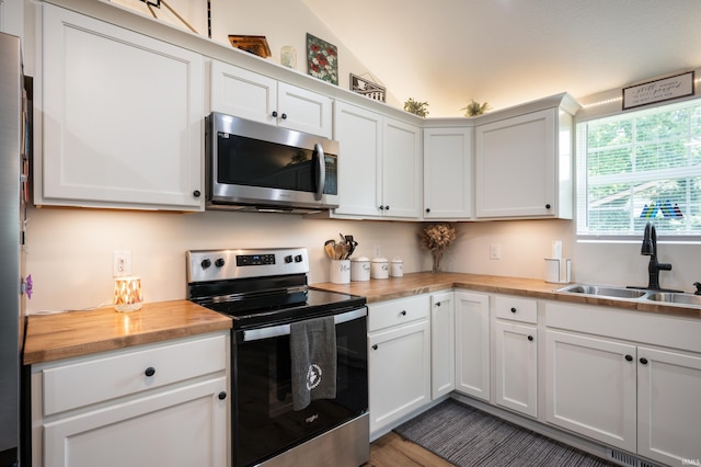 4904 N Hamilton Ln, Muncie, IN 47304 - kitchen with appliances with stainless steel finishes, butcher block countertops, lofted ceiling, and white cabinetry