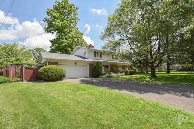 3400 W University Ave, Muncie, IN 47304 - traditional-style home with an attached garage, a chimney, a front lawn, and driveway
