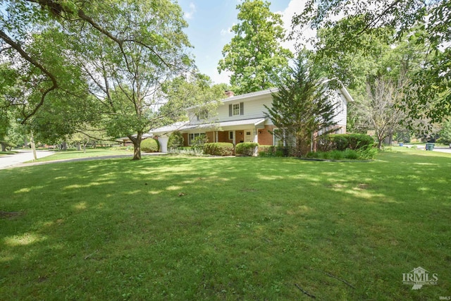 3400 W University Ave, Muncie, IN 47304 - view of front of house featuring a front yard, a chimney, an attached garage, and brick siding