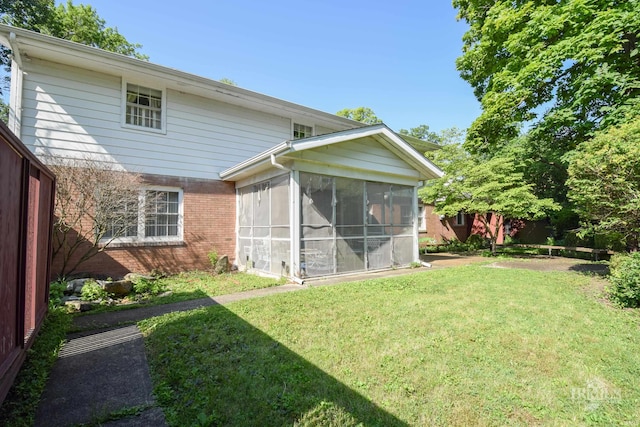 3400 W University Ave, Muncie, IN 47304 - rear view of house with brick siding, a sunroom, and a yard