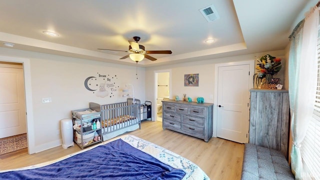 4229 New Birch Dr, Jasper, IN 47546 - bedroom featuring light wood-style floors, a raised ceiling, a ceiling fan, and connected bathroom