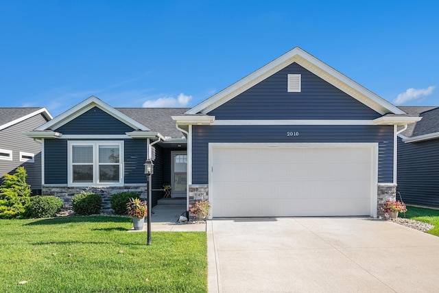 2010 Newbury Cir, Goshen, IN 46526 - view of front of house with stone siding, a front lawn, an attached garage, and concrete driveway