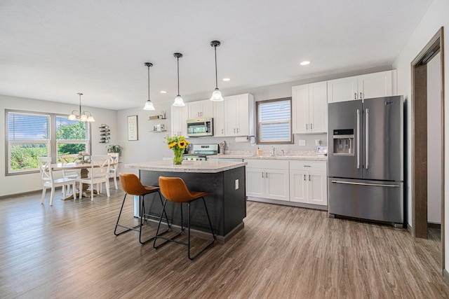 2010 Newbury Cir, Goshen, IN 46526 - kitchen with appliances with stainless steel finishes, white cabinets, a chandelier, a center island, and recessed lighting