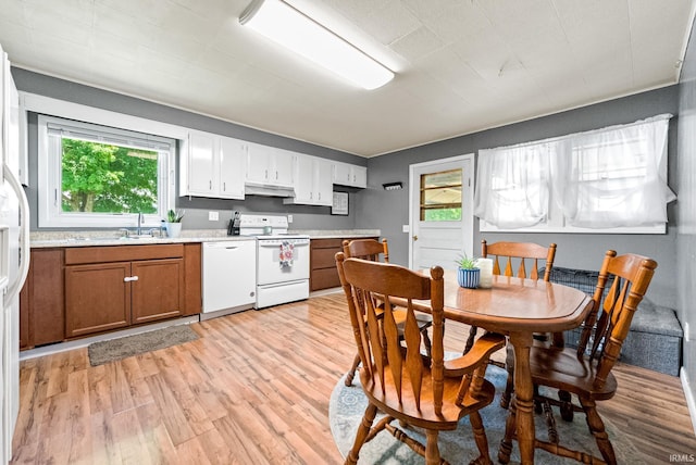 110 N Maple St, South Whitley, IN 46787 - kitchen featuring white appliances, under cabinet range hood, light wood-style floors, and plenty of natural light