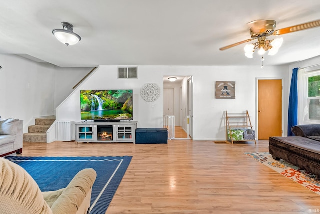 110 N Maple St, South Whitley, IN 46787 - living room with a ceiling fan, wood finished floors, stairs, and radiator