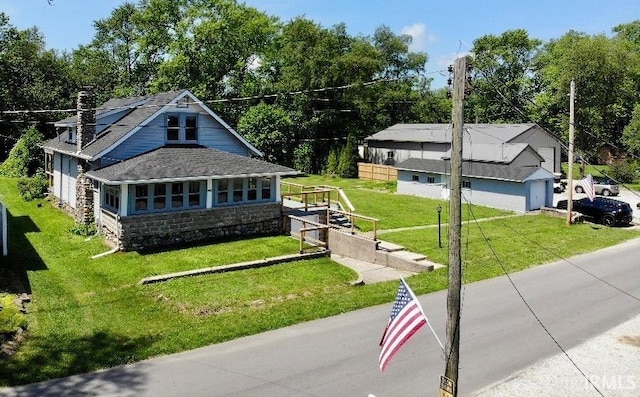 1228 N Main St, Kewanna, IN 46939 - view of front of property with stone siding, roof with shingles, and a front yard