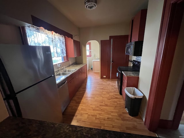 912 Broadway St, Vincennes, IN 47591 - kitchen featuring appliances with stainless steel finishes, arched walkways, light wood-type flooring, and light countertops