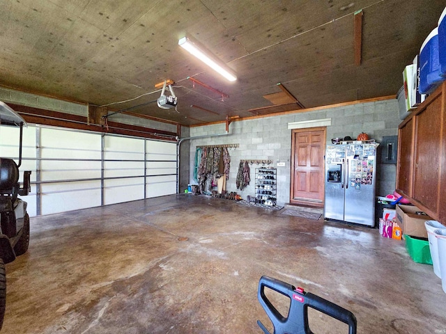 106 N Park Ave, Fowler, IN 47944 - garage with stainless steel fridge with ice dispenser, a garage door opener, and concrete block wall