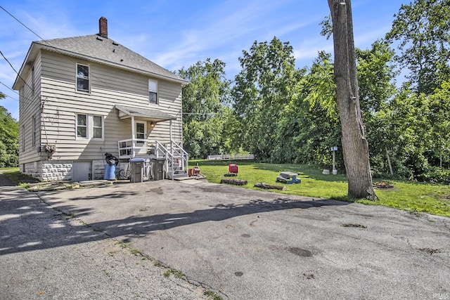 817 Middlebury St, Elkhart, IN 46516 - back of property featuring a yard, a chimney, and a shingled roof