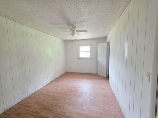 722 N Main St, Sullivan, IN 47882 - empty room featuring light wood-style floors, wood walls, a ceiling fan, and a textured ceiling