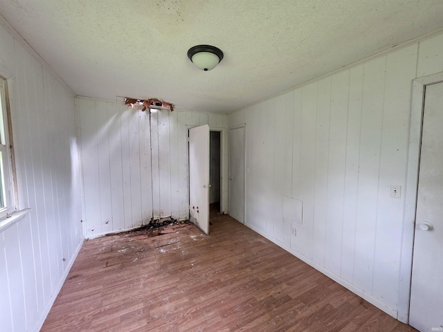 722 N Main St, Sullivan, IN 47882 - unfurnished bedroom featuring wood finished floors, a textured ceiling, and wooden walls
