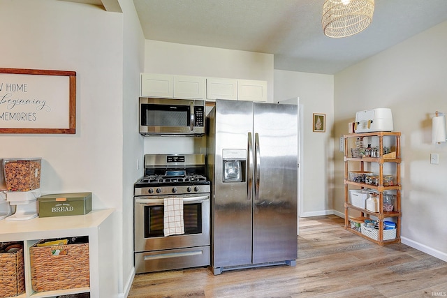 1931 Morton St, Lafayette, IN 47904 - kitchen featuring stainless steel appliances, light wood finished floors, and white cabinetry