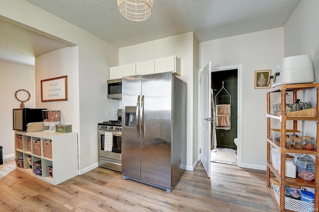 1931 Morton St, Lafayette, IN 47904 - kitchen featuring stainless steel appliances, light wood-style flooring, and white cabinets