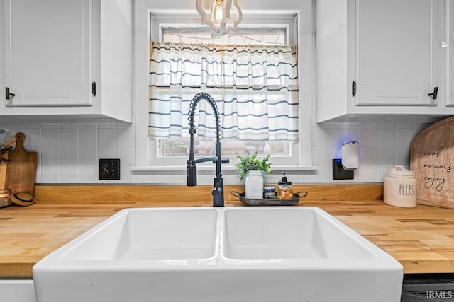 3331 Loral Dr, Anderson, IN 46013 - kitchen with wood counters, white cabinetry, and backsplash