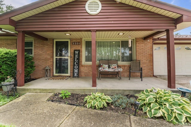 3331 Loral Dr, Anderson, IN 46013 - property entrance with covered porch, a garage, and brick siding