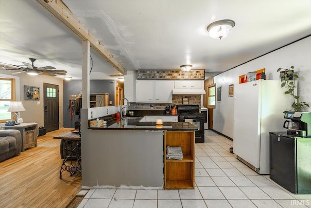 6943 Main St, West Point, IN 47992 - kitchen with black gas range, refrigerator, a peninsula, white cabinets, and decorative backsplash
