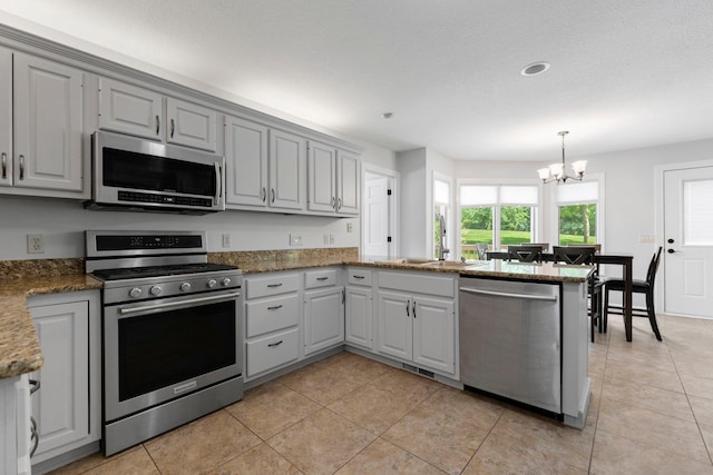 7415 Witling Blvd, Roanoke, IN 46783 - kitchen with stainless steel appliances, a peninsula, a chandelier, and gray cabinetry