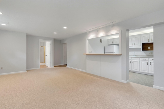 7415 Witling Blvd, Roanoke, IN 46783 - unfurnished living room featuring light carpet, rail lighting, and recessed lighting
