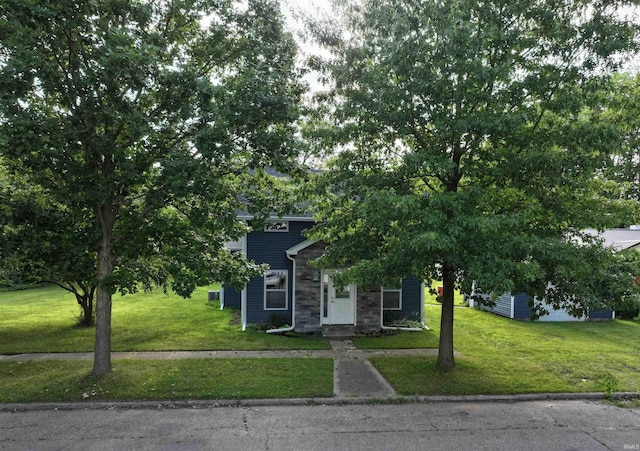 719 N Hathaway St, Winamac, IN 46996 - obstructed view of property featuring a front yard and stone siding