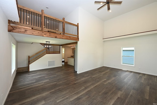 719 N Hathaway St, Winamac, IN 46996 - unfurnished living room with a towering ceiling, wood finished floors, a ceiling fan, a chandelier, and stairway