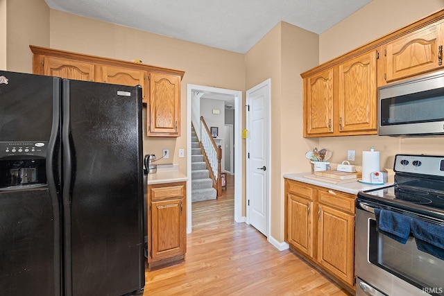 1709 Stonegate Cir, Lafayette, IN 47909 - kitchen featuring appliances with stainless steel finishes, light wood-style flooring, light countertops, and brown cabinets
