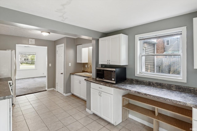 55310 Moss Rd, South Bend, IN 46628 - kitchen with stainless steel microwave, white cabinets, and light tile patterned floors