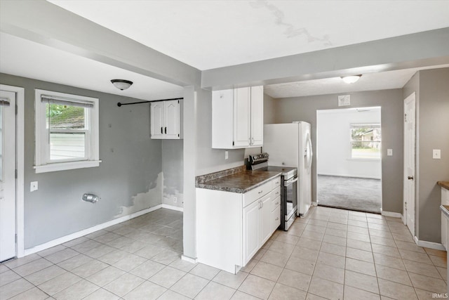 55310 Moss Rd, South Bend, IN 46628 - kitchen featuring stainless steel electric range oven, light tile patterned flooring, white cabinets, and healthy amount of natural light