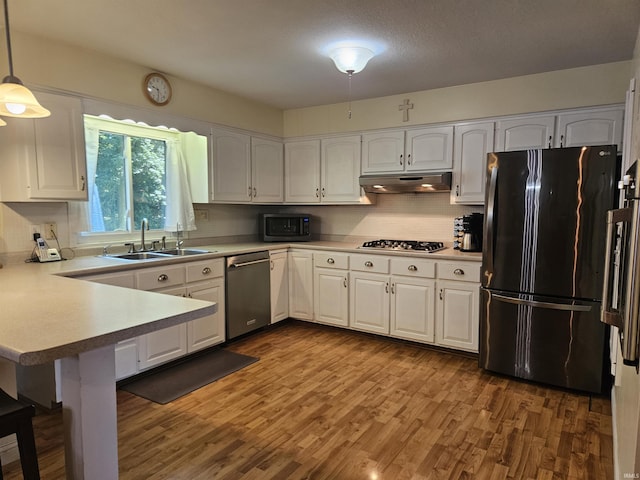3475 W 1175 N Rd, Decatur, IN 46733 - kitchen featuring appliances with stainless steel finishes, white cabinetry, wood finished floors, a peninsula, and under cabinet range hood