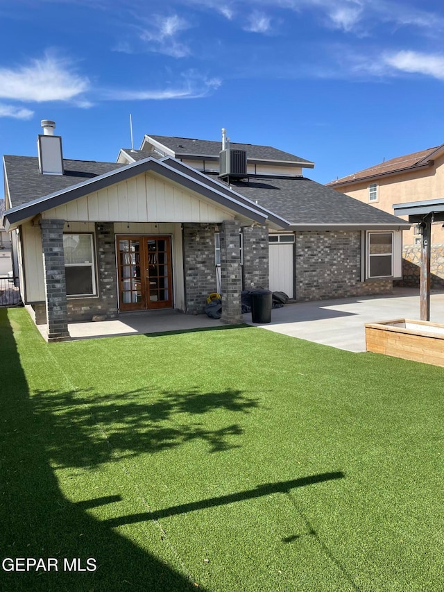 rear view of house featuring a yard, a patio area, and french doors