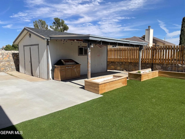 back of house with a shed, a patio area, and a lawn